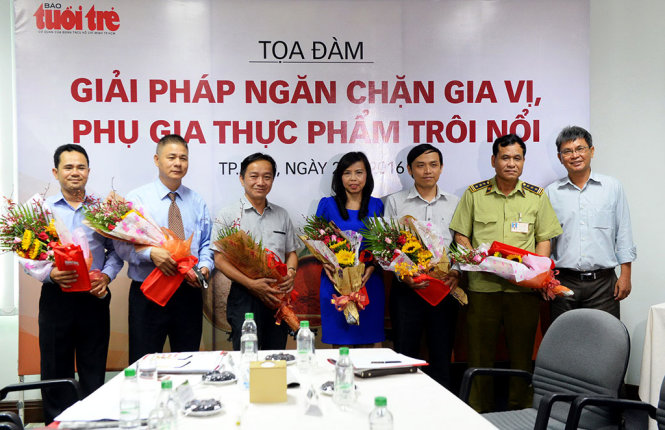 Ông Đỗ Văn Dũng – Phó TBT báo Tuổi Trẻ tặng hoa cho các vị khách mời trong buổi tọa đàm - Ảnh: HỮU KHOA