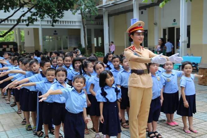 Học sinh Trường tiểu học Đinh Tiên Hoàng (Q.1, TP.HCM) giao lưu với nữ CSGT trong chương trình “Doraemon với an toàn giao thông” sáng 30-9 - Ảnh: NHƯ HÙNG