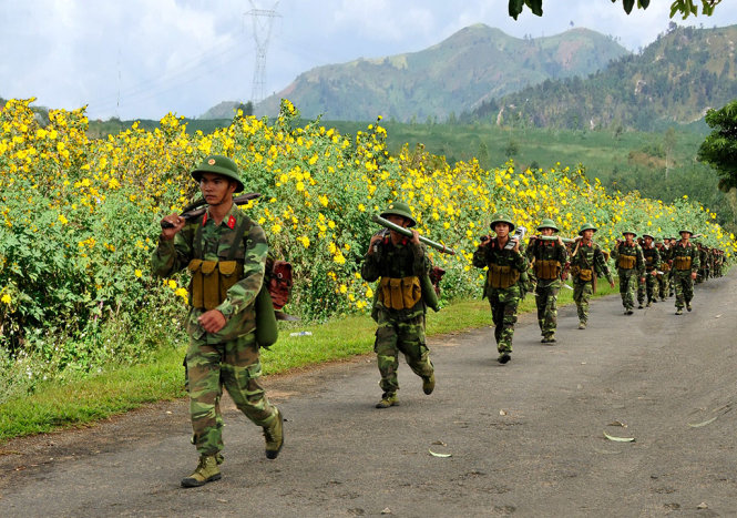 Chiến sĩ binh đoàn Tây Nguyên hành quân giữa mùa hoa cúc quỳ bung nở vàng rực cả núi rừng - Ảnh: Đ.P.