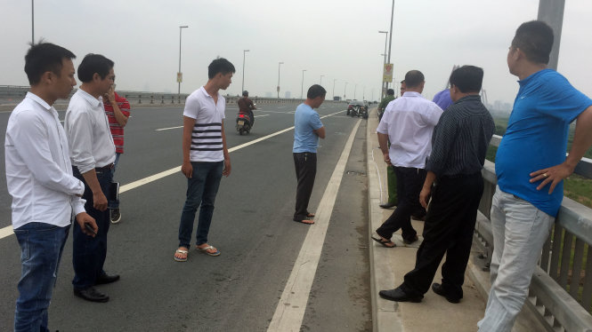 PV Quang Thế (ngoài cùng bìa trái) và chiến sĩ cảnh sát Ngô Quang Hưng (thứ 3 từ trái sang) cùng CQĐT đến cầu Nhật Tân xác định vị trí xảy ra việc PV Quang Thế bị hành hung - Ảnh: THÂN HOÀNG