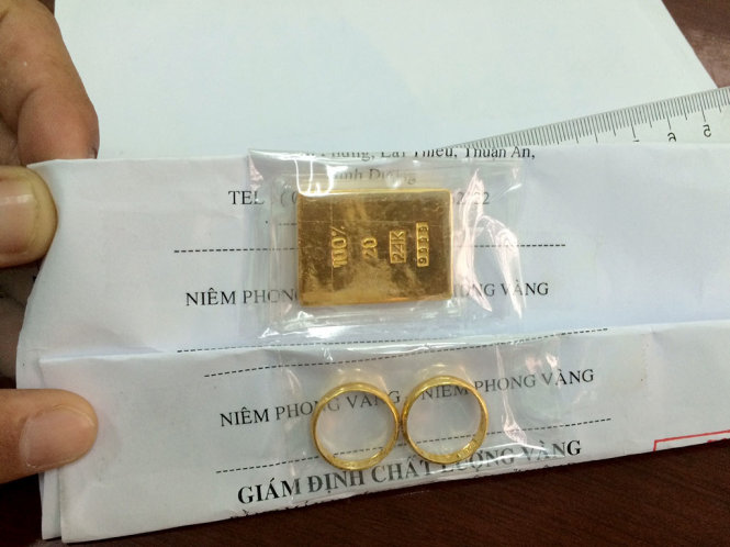 Miếng vàng giả và nhẫn vàng của nạn nhân bị lừa - Ảnh: Công an cung cấp