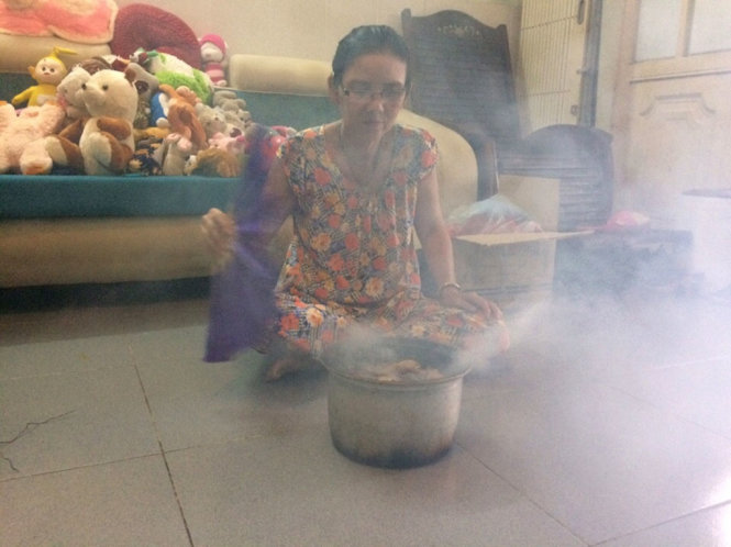 Một người dân dùng vỏ bưởi cam quý trong nhân gian để tạo khói phòng tránh muỗi - Ảnh: TRẦN NGUYÊN