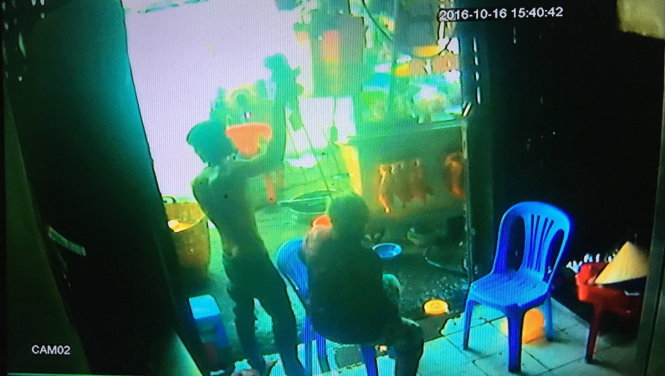 Nam thanh niên khống chế cụ bà bằng xiên nướng thịt - Ảnh: Ngọc Khải cắt từ camera tại lò bánh mì ghi lại