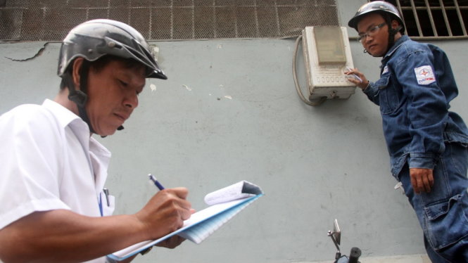 Một khách hàng kiểm tra điện kế điện tử lắp đặt tại nhà mình - Ảnh: Q.KHẢI