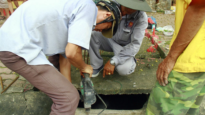 Sau khi bé Hiếu bị nước cuốn tử vong, chủ đầu tư mới cho công nhân tới lắp đặt lại thanh chắn rác vào chiều 17-10 - Ảnh: XUÂN AN