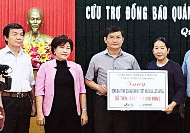 Ông Trần Tiến Dũng, phó chủ tịch UBND tỉnh Quảng Bình, tiếp nhận tiền hỗ trợ từ đoàn công tác của TP.HCM - Ảnh M.HUYỀN