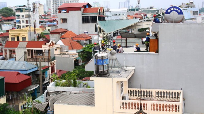 Công nhân khắc phục hư hỏng 2 ngôi nhà số 80 và 81 Thuỵ Khuê do cần cẩu đổ vào - Ảnh: Hà Thanh
