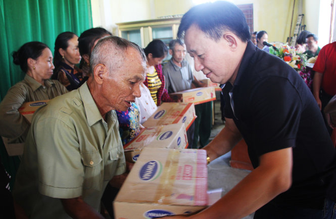 Ông Nguyễn Thanh Tú, chánh văn phòng, chủ tịch Công đoàn công ty cổ phần sữa Việt Nam Vinamilk trao quà cho các hộ dân bị thiệt hại do mưa lũ, ngập lụt ở Cẩm Xuyên, Hà Tĩnh chiều 21-10 - Ảnh: DOÃN HÒA