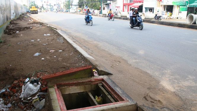 Một hố ga mở nắp không đậy và không có rào cảnh báo tại đoạn đang thi công trên đường Lê Văn Việt - Ảnh: LÊ PHAN