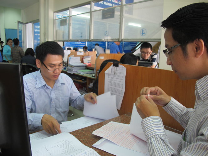 Cán bộ thuế hướng dẫn người dân làm thủ tục quyết toán thuế thu nhập cá nhân tại Cục Thuế TP.HCM - Ảnh: ÁNH HỒNG