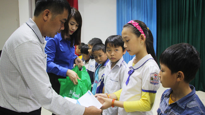 Ảnh: Đại diện báo Tuổi Trẻ và bà Nguyễn Thị Hợi, chuyên viên ban công tác thiếu nhi, Trung ương Đoàn trao học bổng “Ngăn dòng bỏ học” sau lũ cho học sinh huyện Vũ Quang chiều 31-10 - Ảnh: DOÃN HÒA