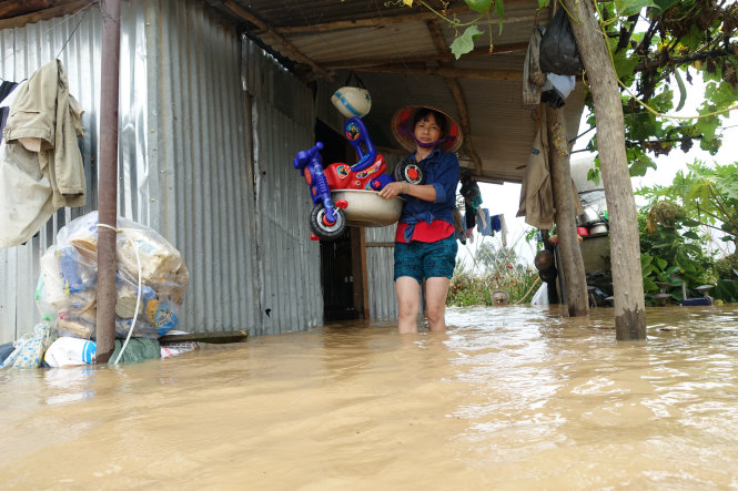 Bà Nghiêm Thị Hoà (xã Lạc Lâm, huyện Đơn Dương) dời đồ đạc chạy lũ - Ảnh: MAI VINH