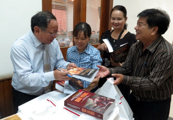 Dịch giả Nguyễn Hữu Dũng (trái) ký tặng bạn dọc hâm mộ Henryk Sienkiewicz hai ấn phẩm mới tái bản - Ảnh: L.Điền