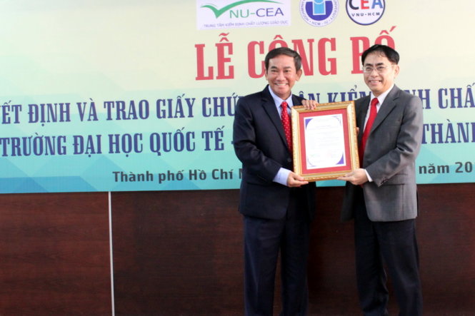 PGS.TS Nguyễn Hội Nghĩa, phó giám đốc ĐHQG TP.HCM trao giấy chứng nhận kiểm định chất lượng giáo dục MOET (bìa phải) cho hiệu trưởng Trường ĐH Quốc tế - Ảnh: BÍCH NGỌC