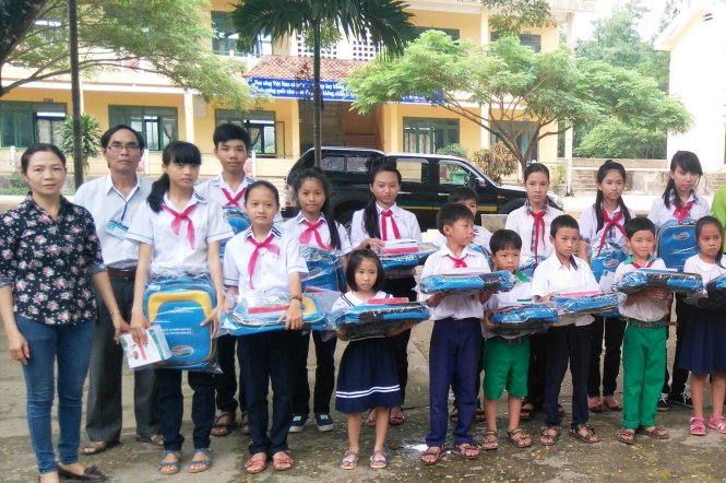 Cô Diễm và thầy Nghĩa trao quà của nhà hảo tâm cho học sinh nghèo vượt khó - Ảnh: NVCC