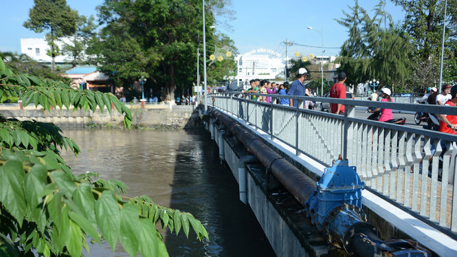 Người dân và người nhà chị T. tập trung tại cầu Kênh Nhánh tiếp tục tìm kiếm thi thể - Ảnh: K.NAM