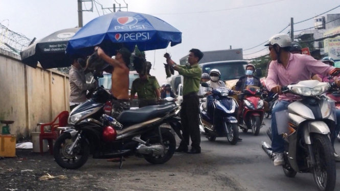 Người đàn ông (cởi trần) giật lại chùm gà nước, đối phó lực lượng kiểm lâm - Ảnh: NGỌC KHẢI