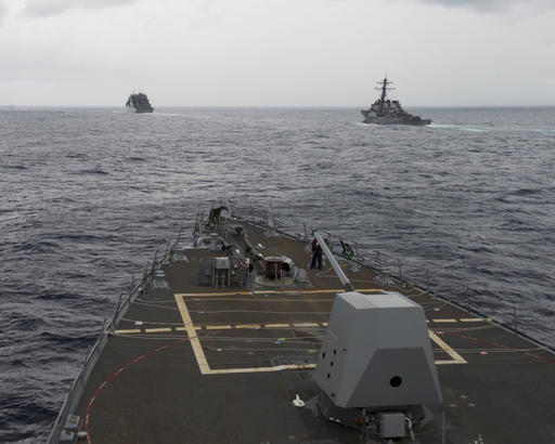 This Oct. 17, 2016 file image provided by the U.S. Navy, shows the guided missile destroyer USS Decatur, right, pulling into position behind the Military Sealift Command USNS Matthew Perry, during a replenishment-at-sea, seen from the bridge of the guided-missile destroyer USS Spruance, in the South China Sea.