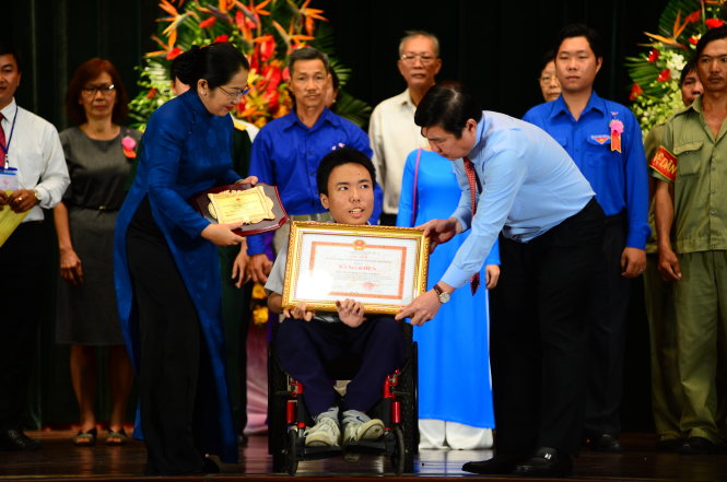 Chủ tịch UBND TP.HCM Nguyễn Thành Phong và Phó bí thư Thành ủy TP.HCM Võ Thị Dung trao bằng khen cho học sinh Trần Phan Thanh Hải (Trường THPT Marie Curie) bị liệt chân nhưng đam mê sáng tạo, trong lễ tuyên dương Những tấm gương thầm lặng mà cao cả sáng 26-11 - Ảnh: QUANG ĐỊNH