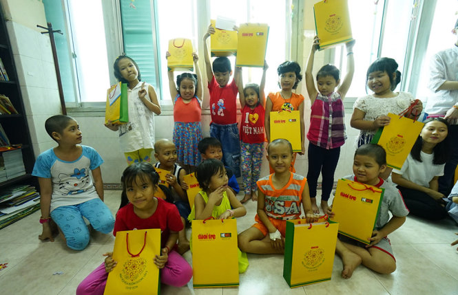 Các bệnh nhi ung thư thích thú với những món quà được báo Tuổi Trẻ trao tặng chiều 2-12 - Ảnh: QUANG ĐỊNH