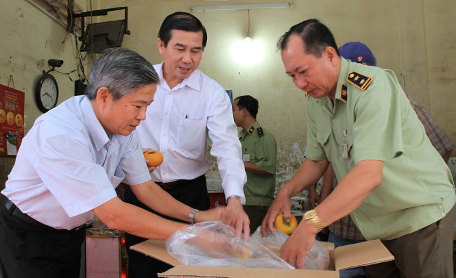 Chủ tịch tỉnh Tiền Giang Lê Văn Hưởng (giữa) và các cơ quan chức năng kiểm tra nông sản Trung Quốc tại chợ Thạnh Trị, TP Mỹ Tho - Ảnh: V.TR.