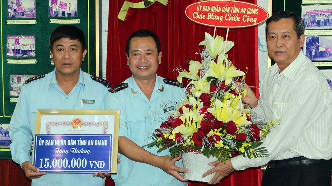 Ông Nưng (phải) trao bằng khen và tiền thưởng cho lãnh đạo Chi cục Hải quan Cửa khẩu quốc tế Tịnh Biên - Ảnh: BỬU ĐẤU