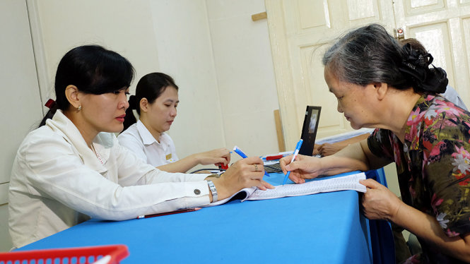 Người dân ký nhận lương hưu tại một điểm chi trả tại quận 1 - Ảnh: VŨ THỦY