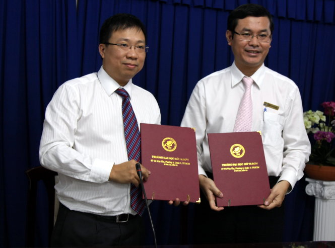 PGS.TS Nguyễn Văn Phúc (phải), hiệu trưởng Trường ĐH Mở TP.HCM, trao bản ký kết hợp tác cho ông Nguyễn Thanh Nhã, giám đốc Sở Quy hoạch - kiến trúc TP.HCM - Ảnh: T.HUỲNH