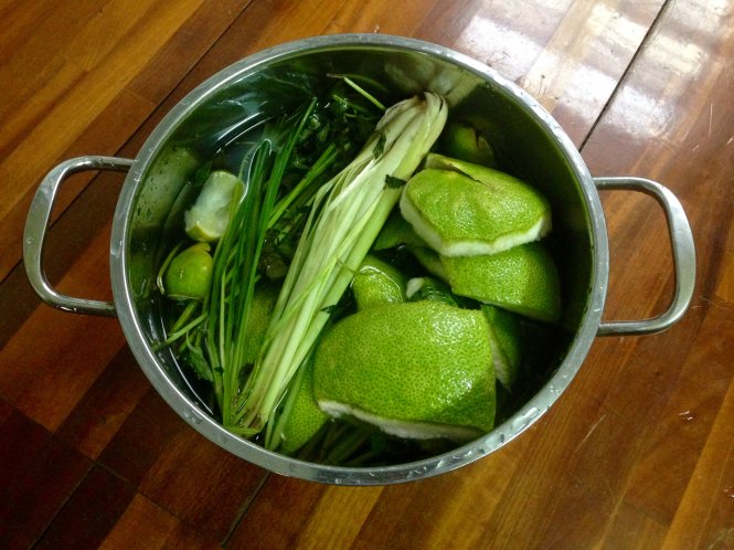 Một nồi nước xông của chị Nga gồm vỏ bưởi, củ sả đập dập, tía tô và rau kinh giới - Ảnh: Lê Đinh