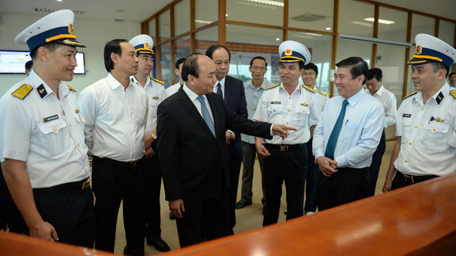 Thủ tướng Nguyễn Xuân Phúc lắng nghe lãnh đạo Tân cảng Sài Gòn giới thiệu về trung tâm điều hành của cảng - Ảnh: Thuận Thắng