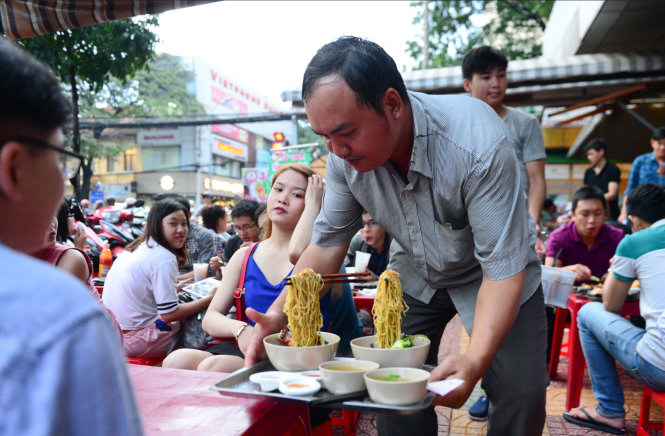 Mì bay từ nhà hàng ra quán vỉa hè. Vắt mì như bay lơ lửng thu hút giới trẻ thích khám phá - Ảnh: MINH PHƯỢNG