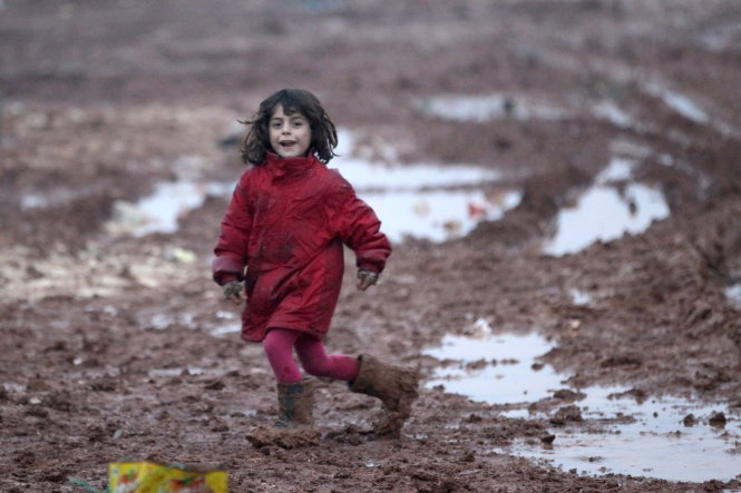 An internally displaced Syrian girl runs through mud in the Bab Al-Salam refugee camp, near the Syrian-Turkish border, northern Aleppo province, Syria December 26, 2016.