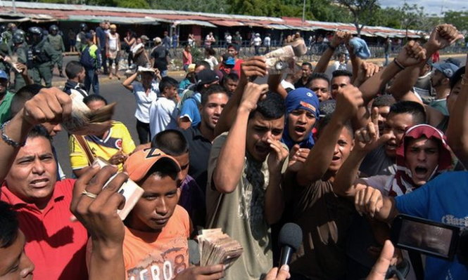 Người dân biểu tình gần Ngân hàng trung ương Venezuela vì tình trạng thiếu tiền mặt trong nước - Ảnh: EPA