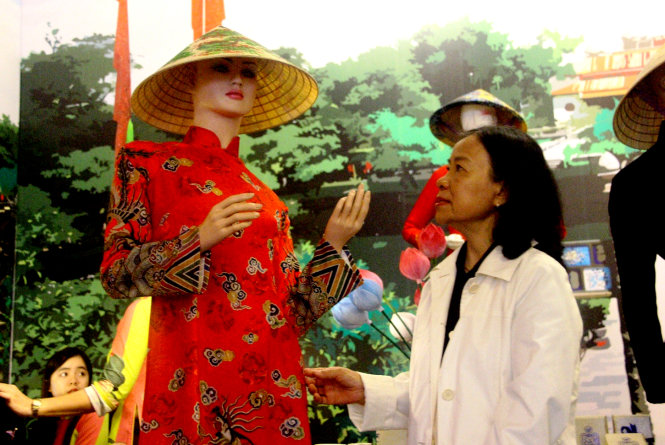 Người xem thưởng lãm những bộ áo dài tại triển lãm “Về với tổ nghề may” - Ảnh: N.Linh