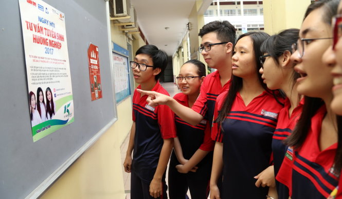 HS lớp 12 trường THPT Bùi Thị Xuân, Q.1, TP.HCM xem thông tin trên poster về Ngày hội tư vấn tuyển sinh - hướng nghiệp năm 2017 do báo Tuổi Trẻ tổ chức - Ảnh: N.HÙNG