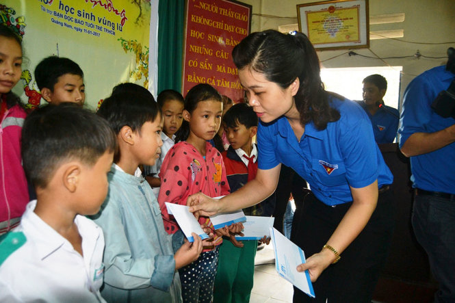 Ông Nguyễn Hoàng Minh Tân- giám đốc đối ngoại và marketing của ATY trao quà cho học sinh vùng lũ. Ảnh: LÊ TRUNG