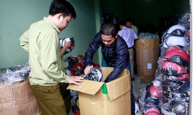 Thu giữ mũ bảo hiểm không rõ nguồn gốc tại cơ sở kinh doanh trên đường Đinh Núp (TP Buôn Ma Thuột) - Ảnh: THÁI THỊNH