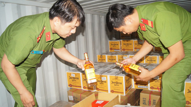 Công an kiểm tra số rượu lậu bị tạm giữ - ẢNH: B.S.