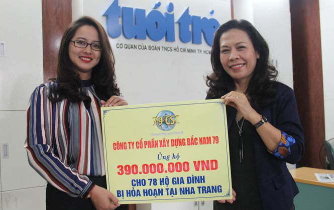 Đại diện Công ty cổ phần xây dựng Bắc Nam 79 (trái) trao tiền ủng hộ cho các hộ dân bị cháy nhà - Ảnh: TRƯỜNG TRUNG