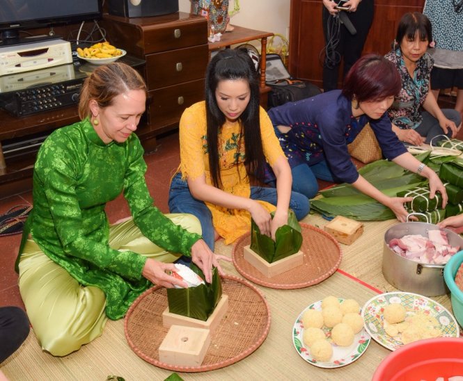 Á hậu Trịnh Kim Chi hướng dẫn bà Mary Etta Tarnowka - Tổng lãnh sự Mỹ tại TP.HCM gói bánh chưng.