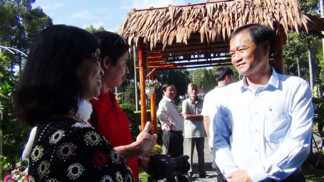 Ông Nguyễn Văn Dương, chủ tịch UBND tỉnh Đồng Tháp, trò chuyện với người dân tham quan - Ảnh: NGỌC TÀI