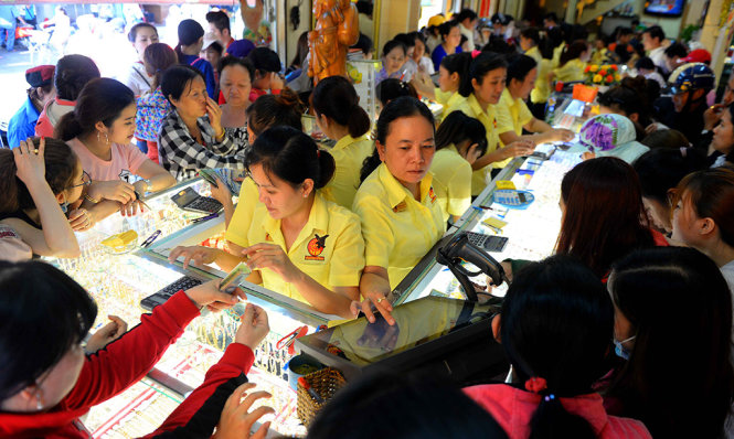 Nhân viên bán vàng mệt mỏi vì người dân đến mua vàng quá đông - Ảnh: HỮU KHOA