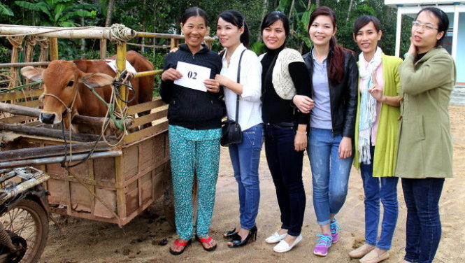 Các bạn trẻ trao tặng con bê cho gia đình bà Trương Thị Sang - Ảnh: ÁNH NGUYỆT