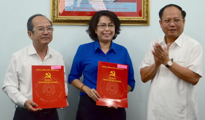 Phó Bí thư thường trực Thàn ủy TP.HCM Tất Thành Cang (phải) trao quyết định cho ông Nguyễn Hoàng Năng và bà Tô Thị Bích Châu - Ảnh: L.H