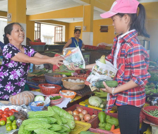 Tiểu thương chợ Tân Hiệp trên đảo Cù Lao Chàm sử dụng túi giấy để gói thực phẩm chứ không dùng túi nilông - Ảnh: Thanh Ba
