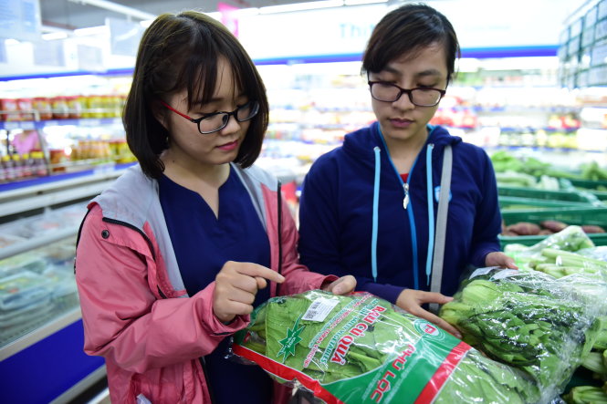 Rau truy xuất nguồn gốc ở TP.HCM vẫn gặp vướng mắc về tem. Trong ảnh: người dân tìm hiểu nguồn gốc rau trước khi mua tại siêu thị ở TP.HCM - Ảnh: HỮU THUẬN
