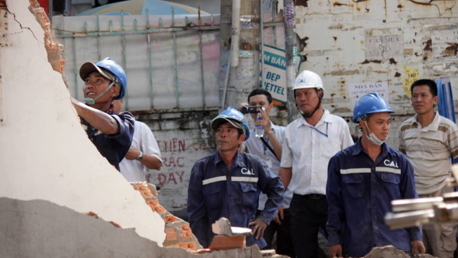 Lực lượng công ích quận 1o tháo dỡ trụ sở khu phố nằm lấn vỉa hè vào chiều 11-3 - Ảnh: Lê Phan