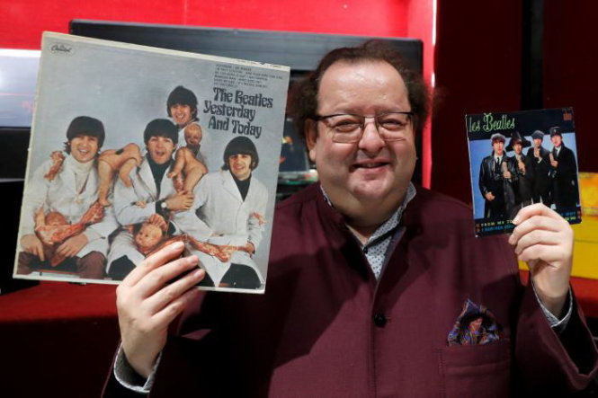 Nhà sưu tập Jacques Volcouve cầm trên tay các đĩa nhạc của The Beatles mà ông bán đấu giá - Ảnh: Reuters