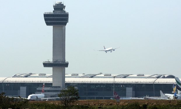 Một máy bay bay qua đài kiểm soát khi nó chuẩn bị hạ cánh tại sân bay John F Kennedy ở New York, Mỹ - Ảnh: AFP