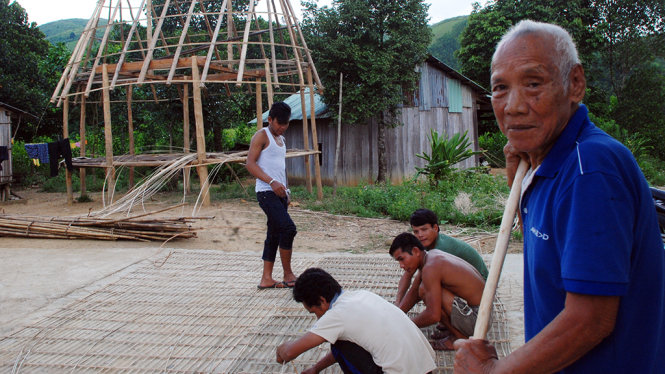 Già ALăng Tăng, người bước qua lời nguyền để ở lại “làng ma” Bút Tưa, đang bày cho lũ trẻ làm cái nhà gươl mới cho làng - Ảnh: VIỆT HÙNG